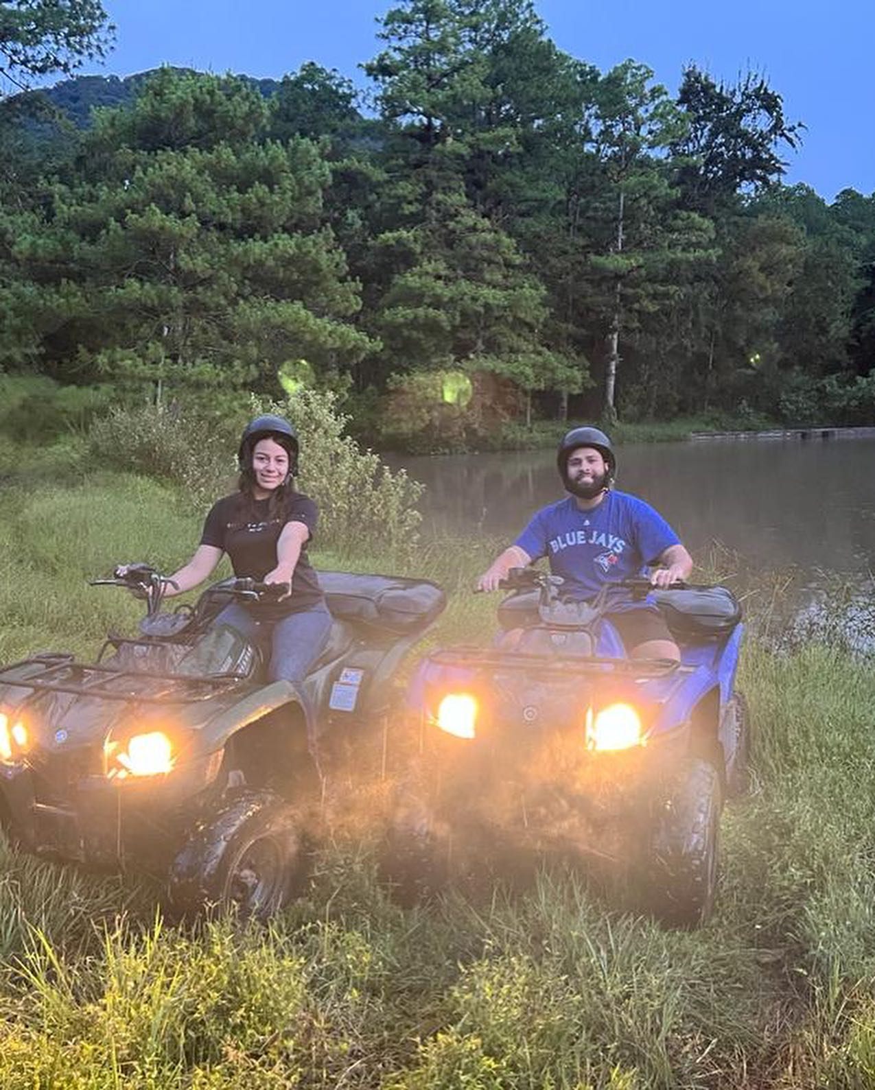 ATV riders waving beside the pond