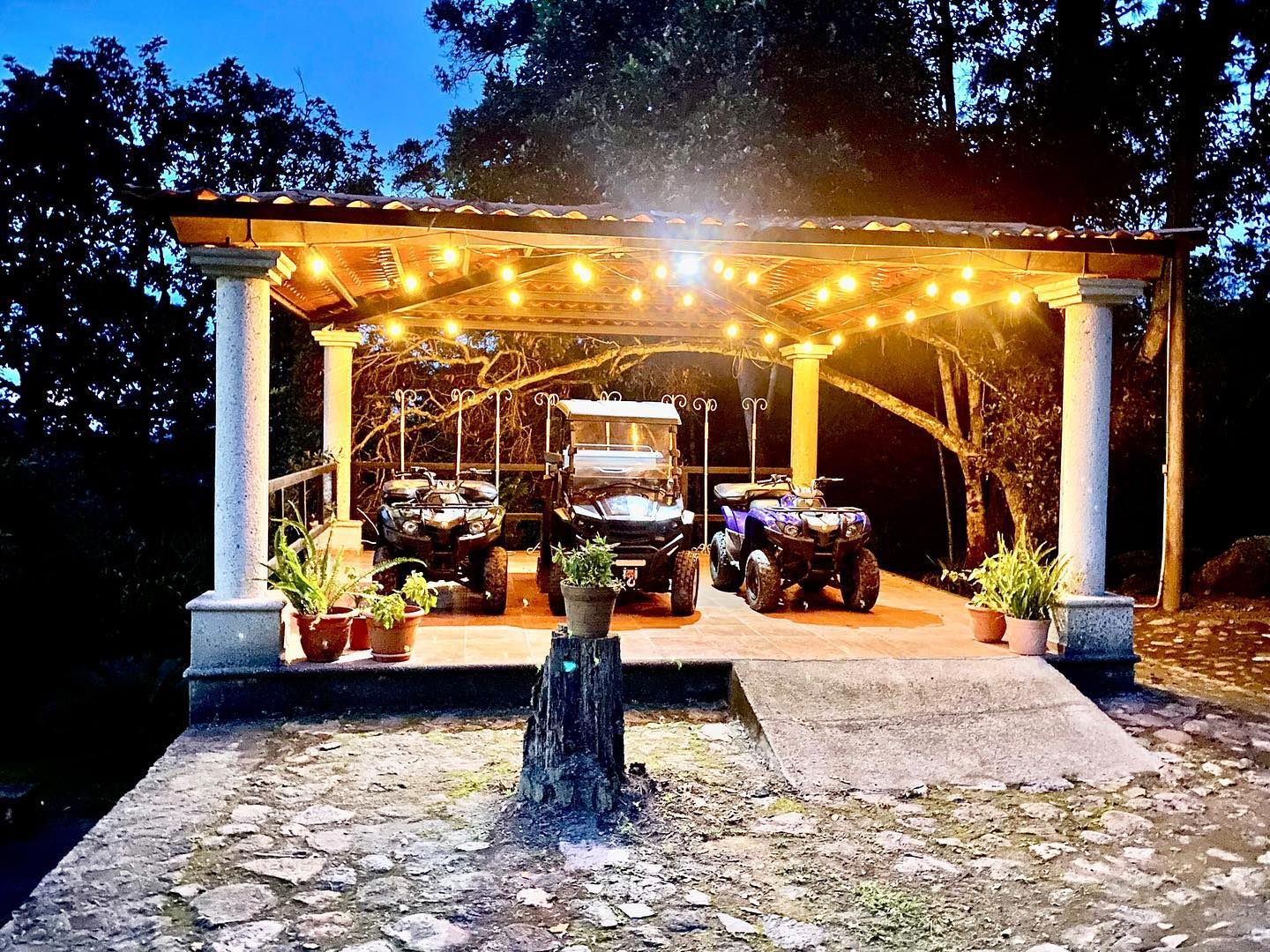 Garden kiosk glowing with string lights at night during an event