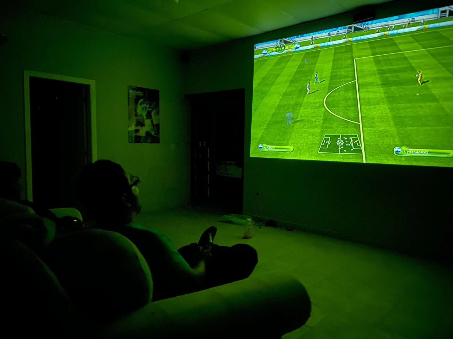 Game room with a big projected screen showing a soccer match