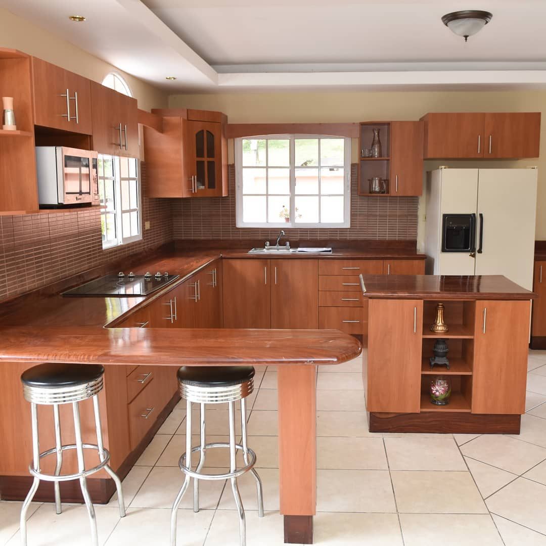 Kitchen with wooden cabinets, island and stools