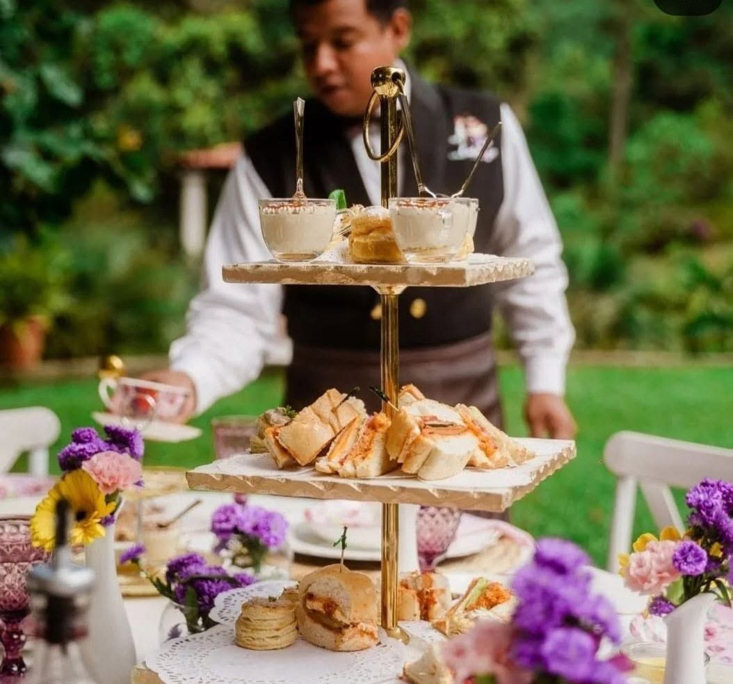 Waiter serving an afternoon tea tower in the garden