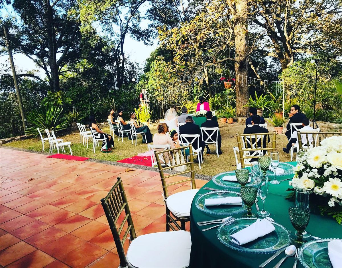 Outdoor wedding reception with guests at emerald-green tables